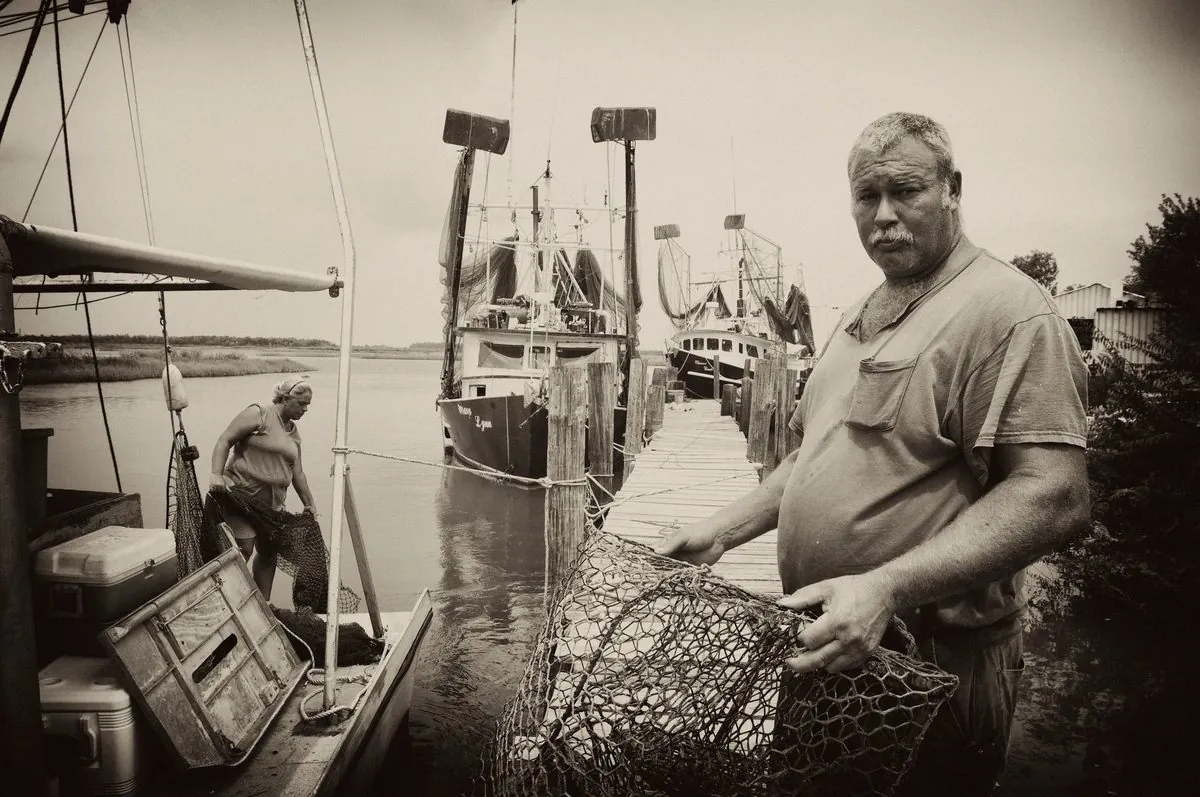 A fisherman on a working dock, in warm-toned black and white